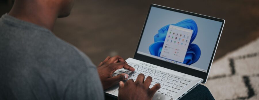 man in gray long sleeve shirt using Windows 11 computer