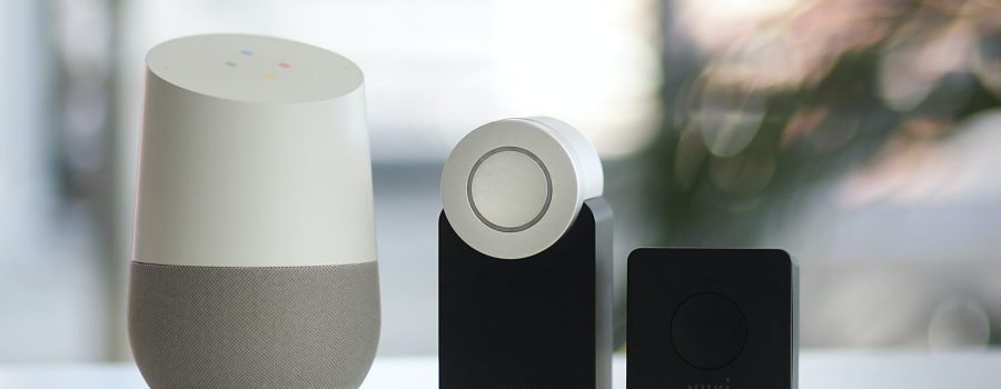 white and gray Google smart speaker and two black speakers