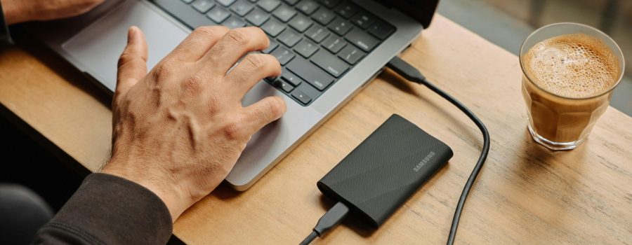 A man sitting at a table using a laptop computer